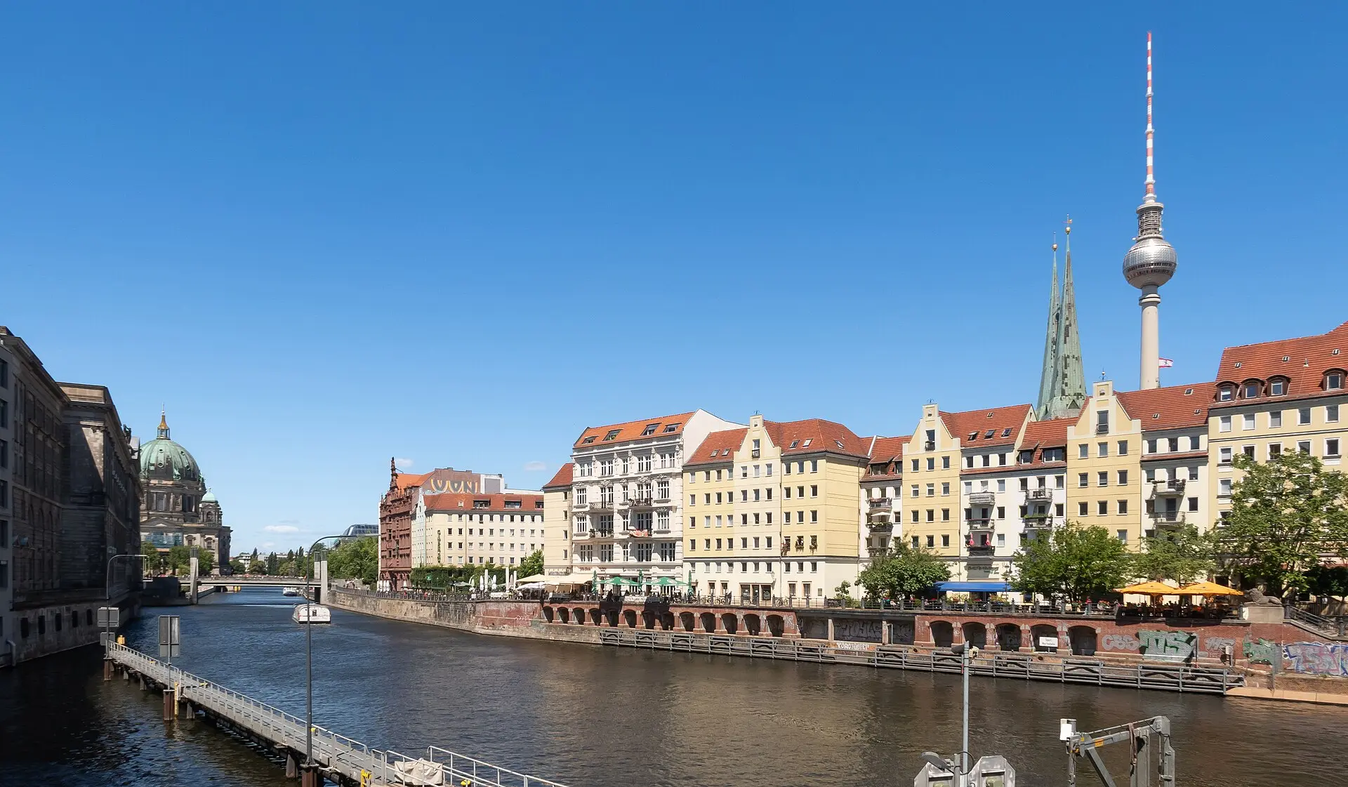 Berlin on a clear day: the TV tower above the coloured houses on the Spree